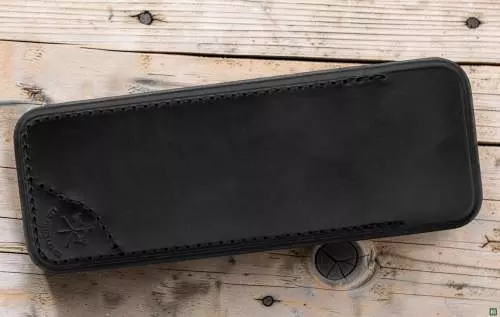 Produktbild: Les Fines Lames Lederetui Sheath Black auf einem Holzboden