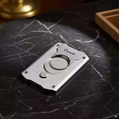 Produktbild: Caseti Paris Zigarrenschneider silber auf einem Tisch