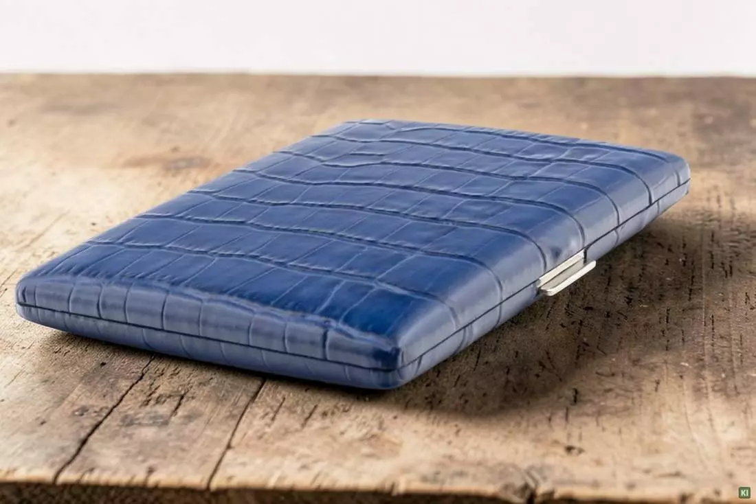 Produktbild: Zigarettenetui Pearl Metall Leder blau Kroko 9er auf einem Tisch